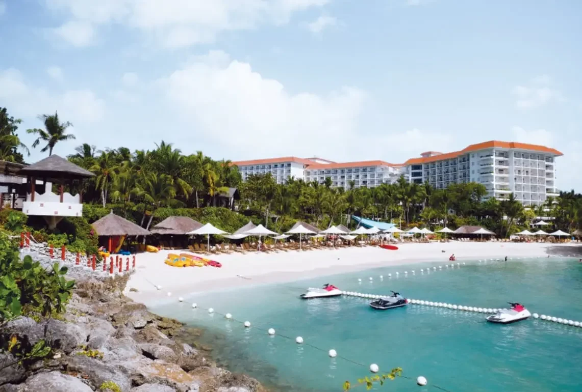 Aerial view of Mactan's east coast resort strip at Punta Engano with reef-fringed shallows and Magellan Bay in the background
